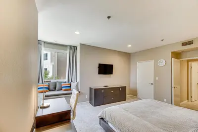 a bedroom with a bed and a tv and a couch at 2 Mi to Hollywood Condo with Pool and Hot Tub Access in Los Angeles