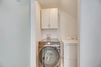 a washer and dryer in a small kitchen with a stairway at 2 Mi to Citadel Outlets! East LA Retreat Near I-5 in Los Angeles