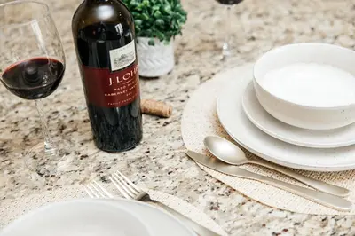 a table with a bottle of wine and plates and silverware at Gorgeous studio steps from The Groove in Los Angeles