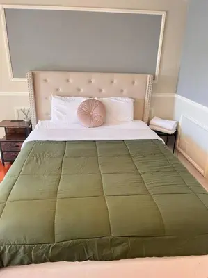 a bedroom with a large bed with a green comforter at Studio Living,Quiet Neighborhood, Near Airport in Walnut