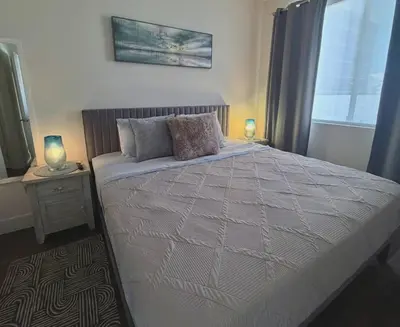 a bedroom with a bed with two lamps and a window at Beachside Luxury Apartment I Free Parking in Los Angeles