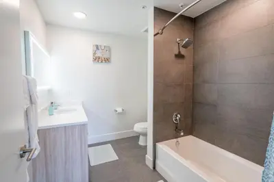 a bathroom with a tub and a toilet and a sink at Beachside Luxury Apartment I Free Parking in Los Angeles