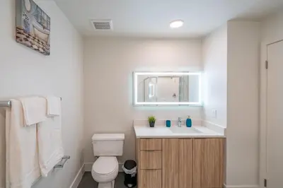 a bathroom with a toilet and a sink and a mirror at Beachside Luxury Apartment I Free Parking in Los Angeles