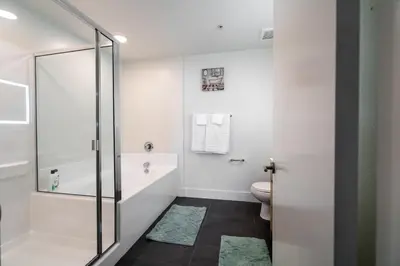a white bathroom with a shower and a toilet at Beachside Luxury Apartment I Free Parking in Los Angeles