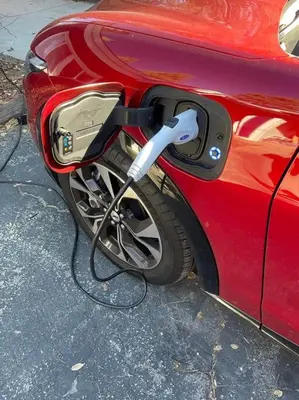 a red car is hooked up to a car charger at Family-friendly, AC, Hot Tub, Walk 2 Park & Lake in Big Bear Lake