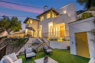 a white house with chairs and a balcony at Belden Modern Villa in Los Angeles