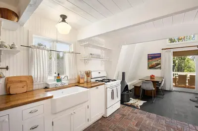 a white kitchen with a sink and a stove at Scout's Lakehouse Retreat by Colby & Conrad in Lake Arrowhead