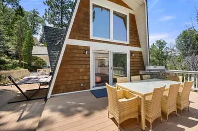 a tiny house with a table and chairs on a deck at Scout's Lakehouse Retreat by Colby & Conrad in Lake Arrowhead