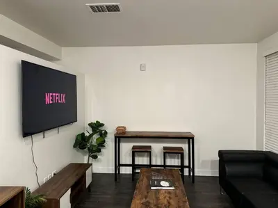 a living room with a couch and a tv on a wall at Modern and Lavish apartment in Glendale