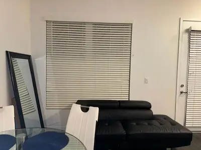 a living room with a black couch and a glass table at Stylish and Elegant apartment in Glendale