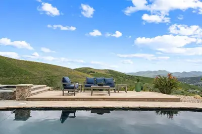 a couple of chairs sitting next to a swimming pool at Bouquet Cottage home in Thousand Oaks