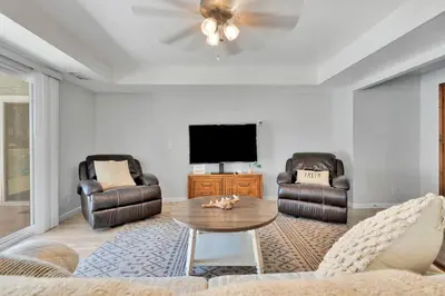 a living room with two chairs and a tv at Oasis Condo on the Fairway in Victorville