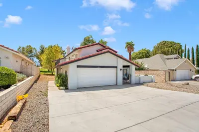a house with a garage in front of a driveway at Oasis Condo on the Fairway in Victorville