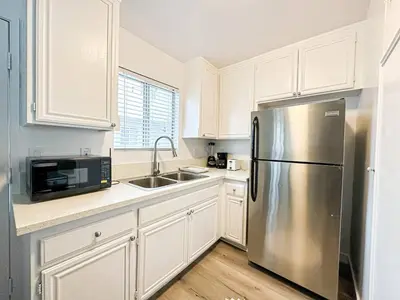 a kitchen with white cabinets and a stainless steel refrigerator at Charming 2-BR, 2-Story Retreat in Heart of LA - BR4 in Los Angeles