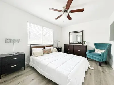 a bedroom with a bed with a ceiling fan and a blue chair at Charming 2-BR, 2-Story Retreat in Heart of LA - BR4 in Los Angeles