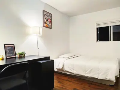 a bedroom with a bed and a desk and a window at Coastal Comfort Homestay in Santa Monica in Los Angeles