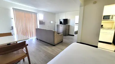 a living room with a couch and a kitchen at MC Pacific Inn & Suites Torrance in Torrance
