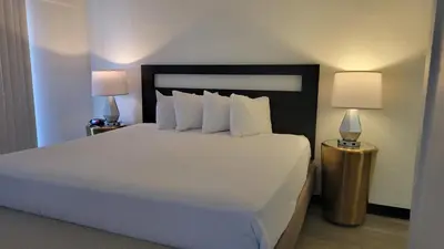 a bedroom with a large white bed with two lamps at MC Pacific Inn & Suites Torrance in Torrance