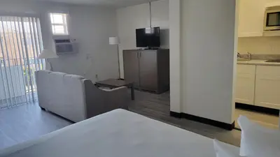 a living room with a couch and a television at MC Pacific Inn & Suites Torrance in Torrance