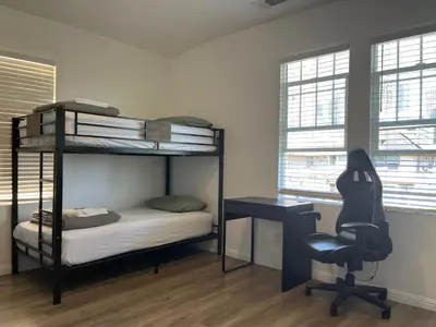 a bedroom with bunk beds and a desk and a chair at Green House in Los Angeles
