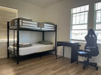 a bedroom with a bunk bed and a desk and a chair at Green House in Los Angeles