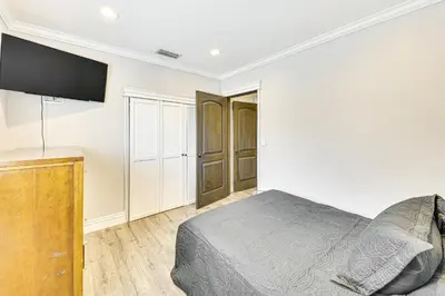 a bedroom with a bed and a flat screen tv at Game Room, Pool! Family Home 25 Mi to Disneyland in West Covina