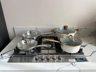 three pots and pans sitting on top of a stove at New Renovated House in Little Saigon in Midway City