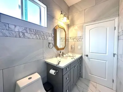a bathroom with a sink and a toilet and a mirror at New Renovated House in Little Saigon in Midway City