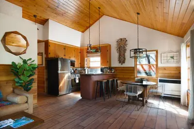 a kitchen with wooden ceilings and a table with chairs at The Nest On Towne Trail - Hot Tub, BBQ, Fire Pit in Big Bear Lake
