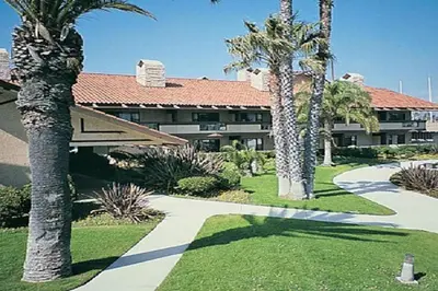 a resort with palm trees and a walkway at Beautiful Resort in Harbortown Point 1BD near Marina Park in Ventura