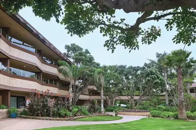 a building with palm trees in front of it at Beautiful Resort in Harbortown Point ST near Marina Park in Ventura