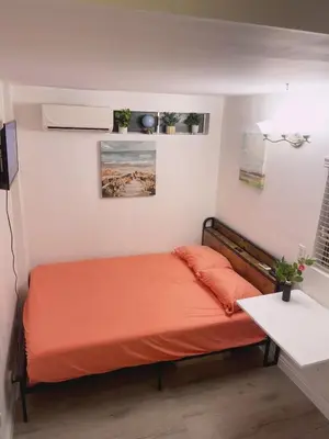 a bedroom with a bed with an orange bedspread at private & Quiet unit D Bed & bath in Rosemead