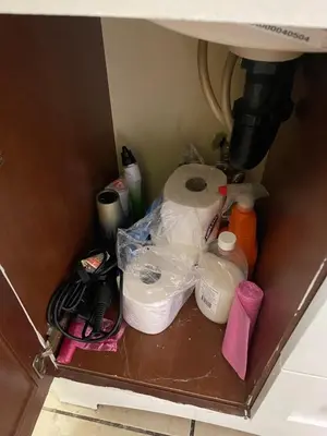 a shelf underneath a sink with toilet paper under a sink at private & Quiet unit D Bed & bath in Rosemead