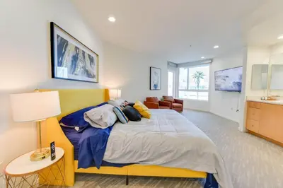a large bedroom with a yellow bed and a table at Lavish Living Lux Marina Views in Los Angeles