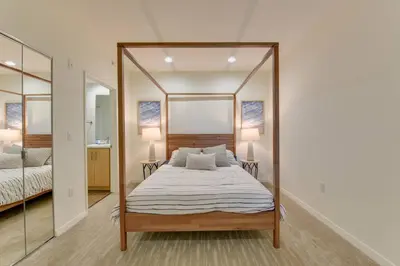a bedroom with a canopy bed and a mirror at Lavish Living Lux Marina Views in Los Angeles