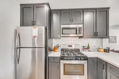 a kitchen with stainless steel appliances and gray cabinets at 7 Mi to DTLA! Family Home with Furnished Deck in Los Angeles
