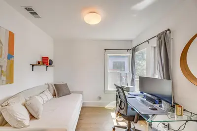 a living room with a couch and a desk with a computer at 7 Mi to DTLA! Family Home with Furnished Deck in Los Angeles