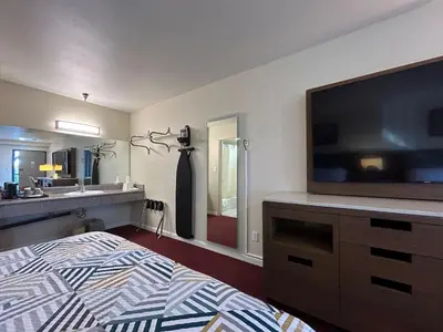 a bedroom with a tv and a bed and a sink at Studio 6 Suites Santa Ana, CA in Santa Ana
