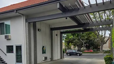 a car is parked in front of a building at Studio 6 Suites Santa Ana, CA in Santa Ana