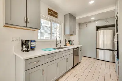 a kitchen with white cabinets and a sink at 2 Mi to SoFi Stadium Updated Inglewood Home! in Los Angeles