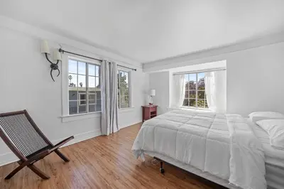 a white bedroom with a bed and two windows at Spacious Chic 5 Bedroom Perfect for Large Group With parking in Los Angeles