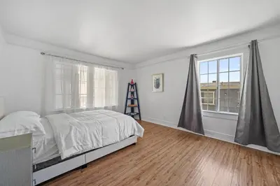 a bedroom with a bed and two windows and a ladder at Spacious Chic 5 Bedroom Perfect for Large Group With parking in Los Angeles