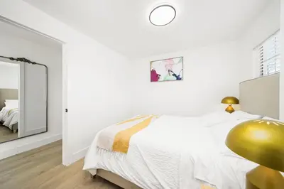 a white bedroom with a bed and a mirror at 2Bedroom home - Marengo Estate in Alhambra