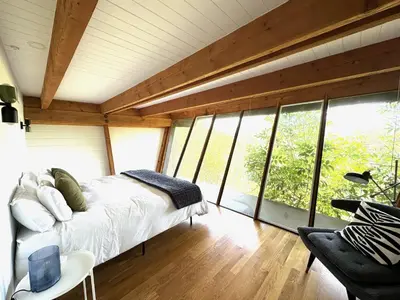 a bedroom with a bed in a room with windows at Architectural Marvel in Hollywood Hills with Views in Los Angeles