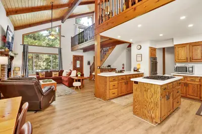 a kitchen and living room with wooden cabinets at Four little bears cabin #2490 in Big Bear Lake