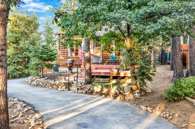 a log cabin with a bench in front of a house at The nest on towne trail #2480 in Big Bear Lake