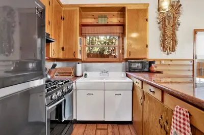 a kitchen with wooden cabinets and a white sink at The nest on towne trail #2480 in Big Bear Lake