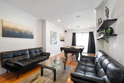 a living room with a leather couch and a pool table at Elegance Escape Sleeps 10 Pool with Jacuzzi in Los Angeles