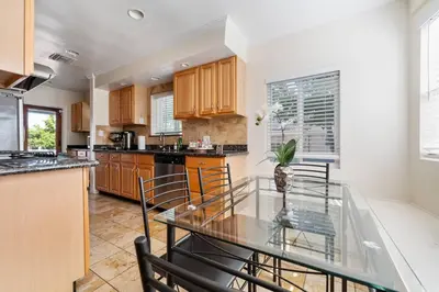 a kitchen with a glass table and some chairs at Elegance Escape Sleeps 10 Pool with Jacuzzi in Los Angeles