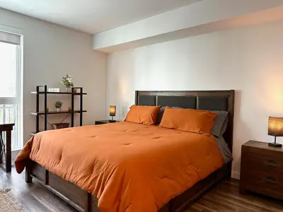 a bedroom with a large bed with an orange bedspread at Hollywood CHIC Studio with FREE parking in Los Angeles